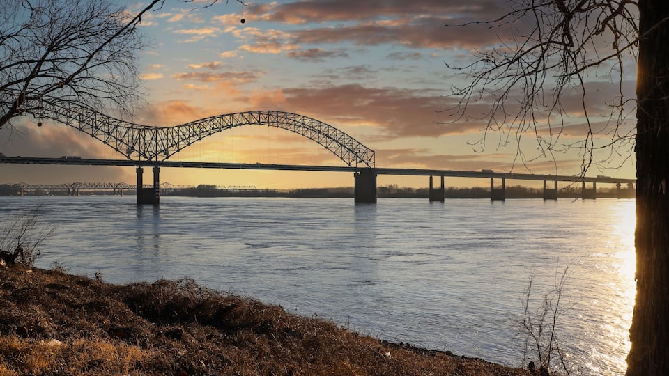A bridge over a river during sunset.