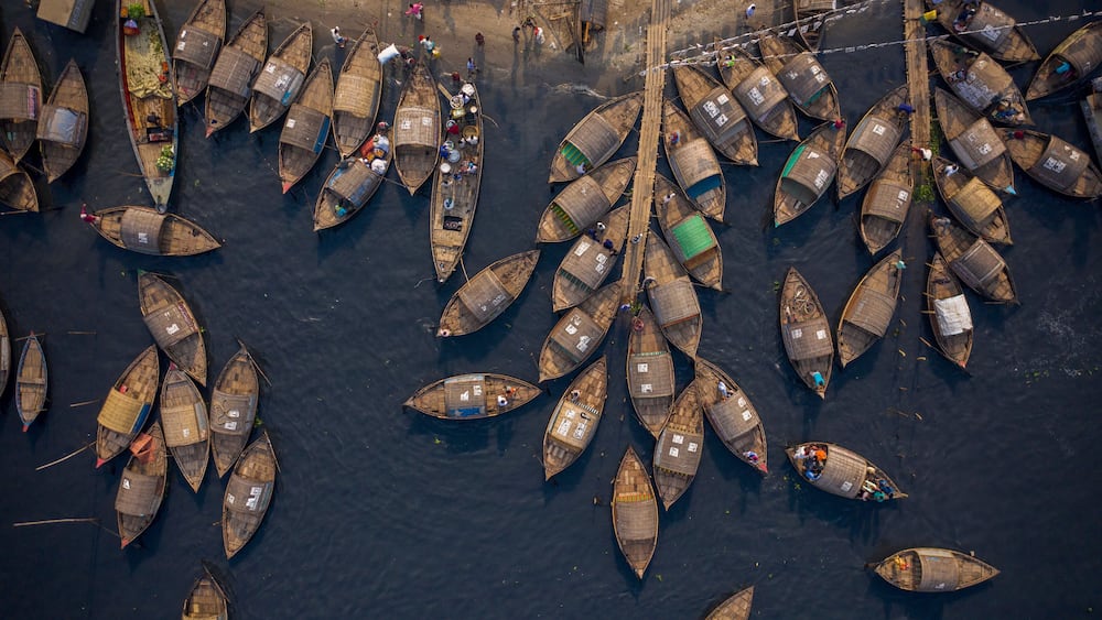 Aerial view of traditional fishing boat docked along Shitalakshya river in Bandar township, Dhaka state, Bangladesh.