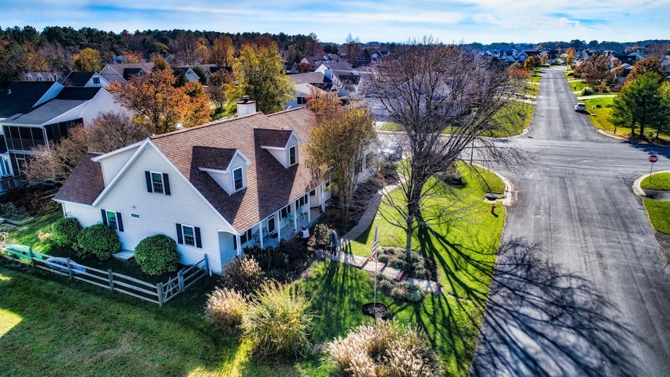 A suburban neighborhood with houses, a road, and autumn foliage.