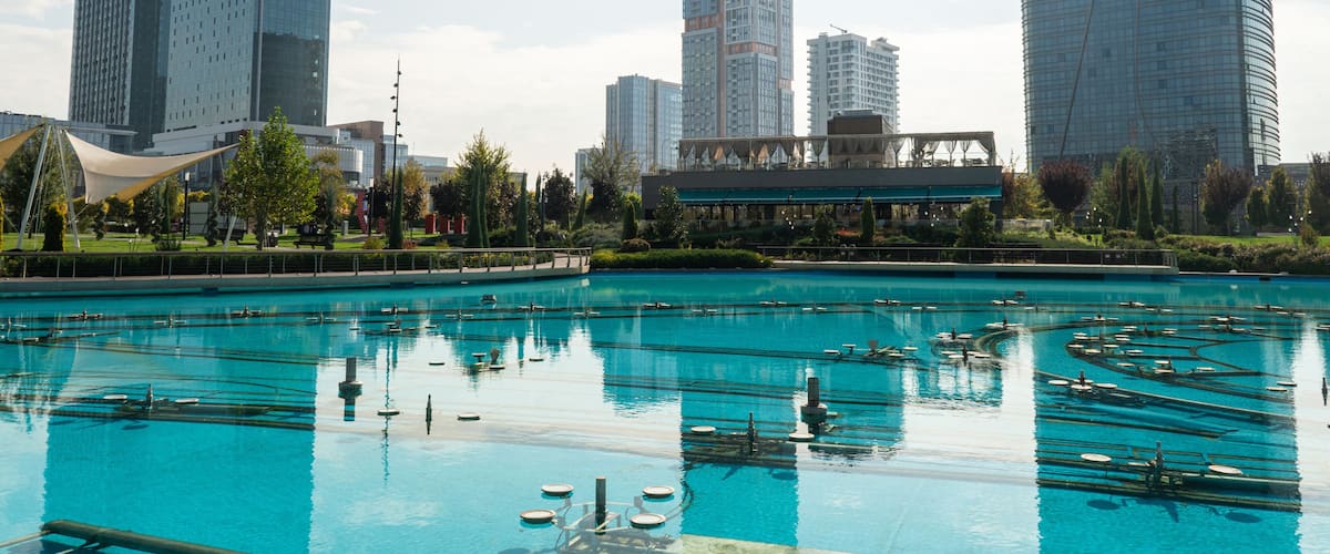 Awesome view of contemporary buildings reflected in pool of Tashkent City Park in Tashkent, Uzbekistan. The park is a popular recreational gathering place among residents and tourists.