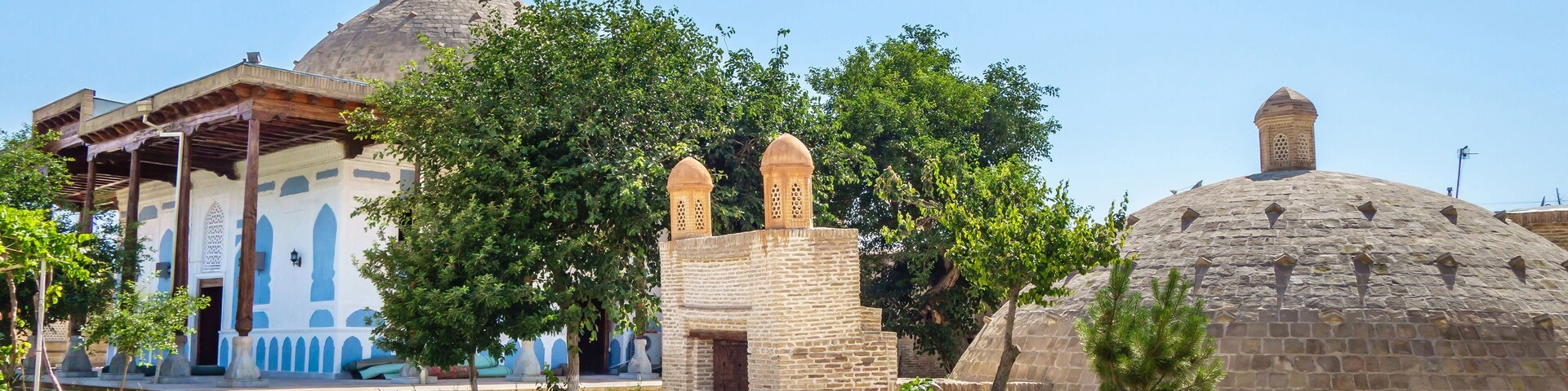 Buildings of Khalifai Khudoydod complex in Bukhara, Uzbekistan. Foreground: entrance to the underground water reservoir (sardoba) and its dome, background: mosque. Complex was built in 17-18 centuries