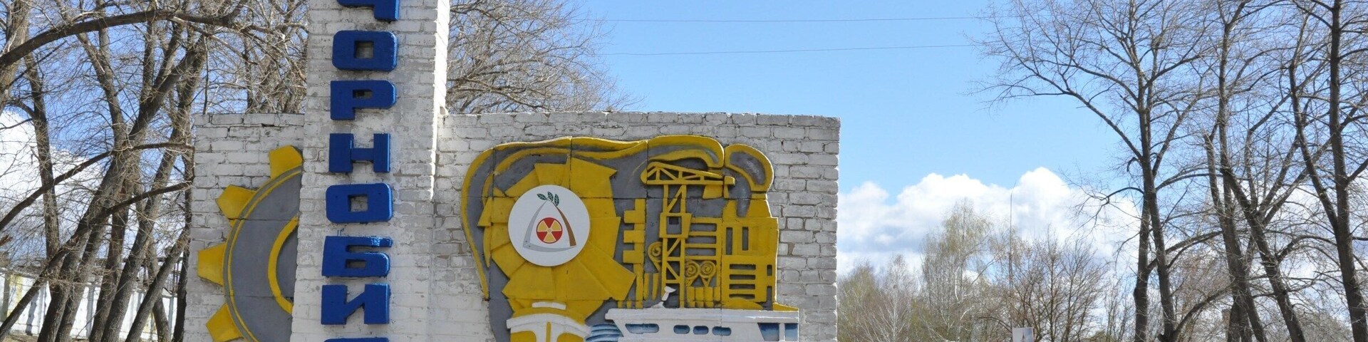 Welcome to Chornobyl! After your tour vehicle passes the guard post marking the boundary of the Nuclear Exclusion Zone, there is a lengthy drive through forest before you encounter this sign marking the entrance to the town of Chornobyl. It's a shadow of what it was before 1986, but workers still live in the town as they continue construction projects on the decommissioned plant. There is a hotel (used by some tour groups to overnight), a tasty restaurant, a fire station, a church, some government buildings, a tiny store, and a touching memorial to both the victims of the Chornobyl disaster and to Fukushima as well. More details in this post: http://www.thecuriouszephyr.com/2015/04/chernobyl-where-nuclear-tourism-meets.html