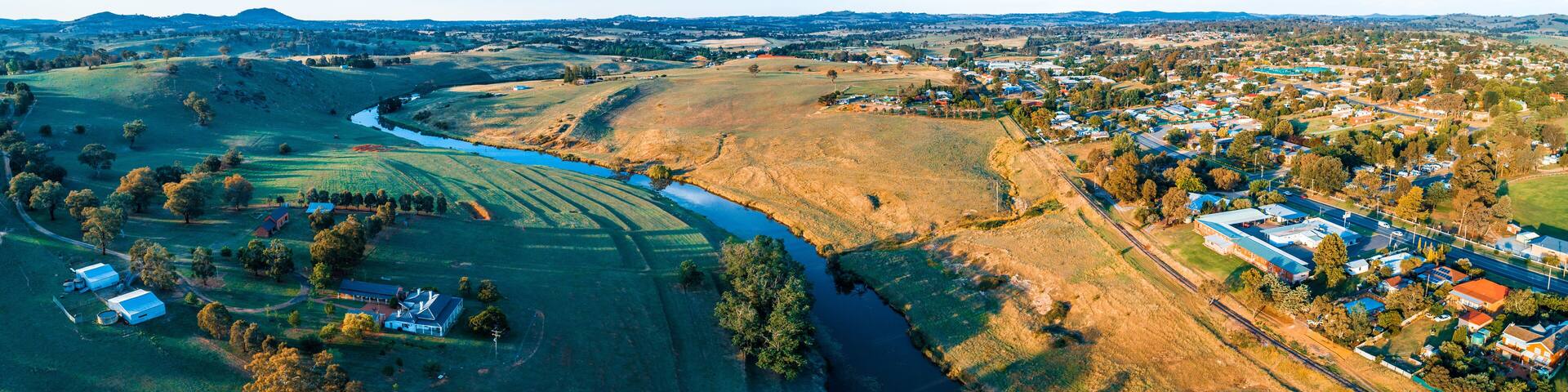 Beautiful aerial panorama of Yass town and river surrounded by grasslands at sunset