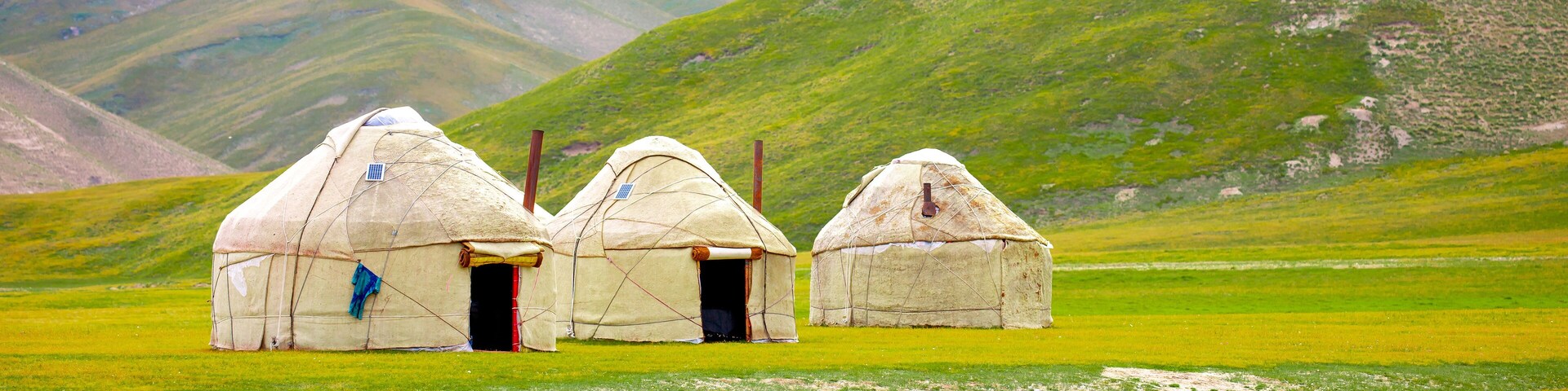 Yurt. National old house of the peoples of Kyrgyzstan and Asian countries. national housing. Yurts on the background of green meadows and highlands. Yurt camp for tourists.