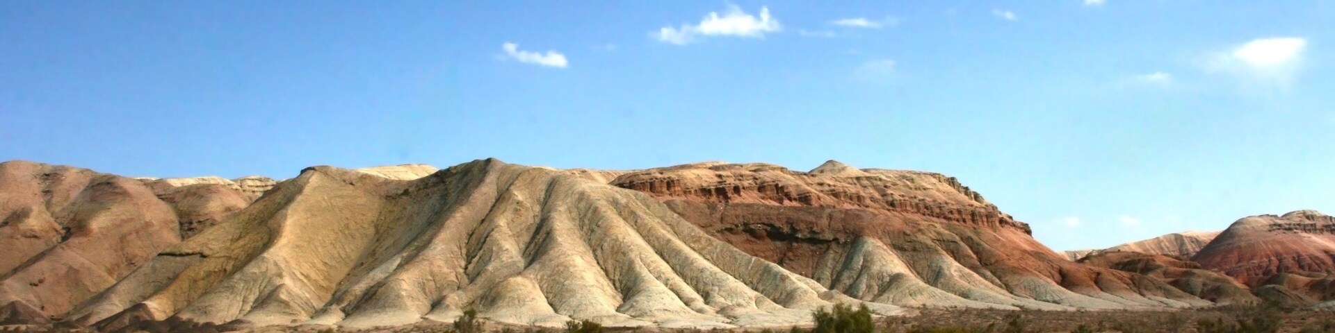 Aktau Mountains on sunrise. Beautiful landscape of colorful mountains in desert. Nature reserve Altyn Emel. Kazakhstan. Panorama with copy space