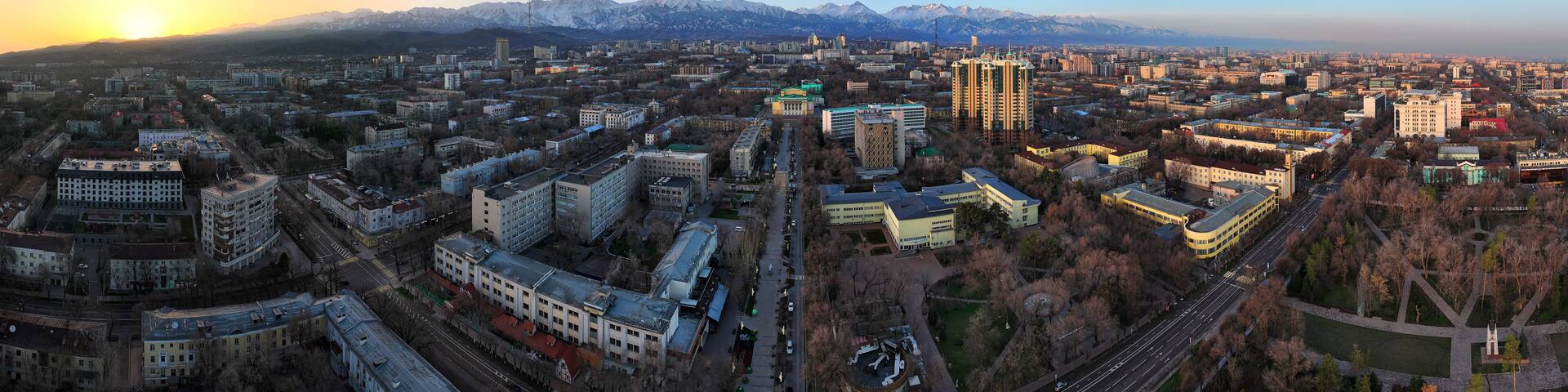 View from a quadcopter of the central part of the largest city of Kazakhstan - Almaty in the early spring morning against the backdrop of the Trans-Ili Alatau mountain range