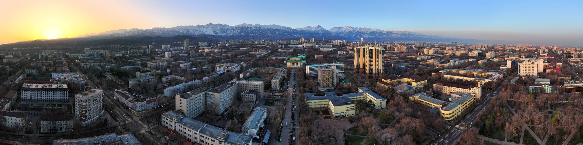 View from a quadcopter of the central part of the largest city of Kazakhstan - Almaty in the early spring morning against the backdrop of the Trans-Ili Alatau mountain range