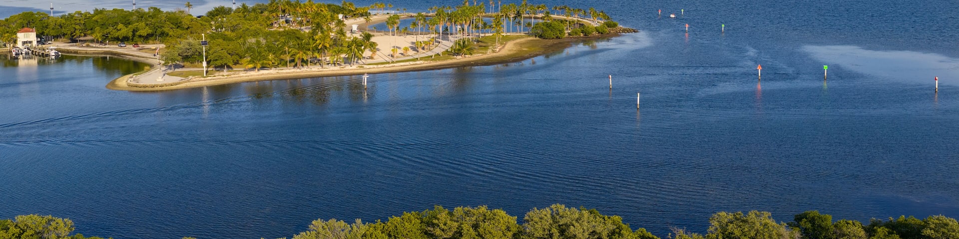 A tropical island with a beach, palm trees, and a lighthouse.