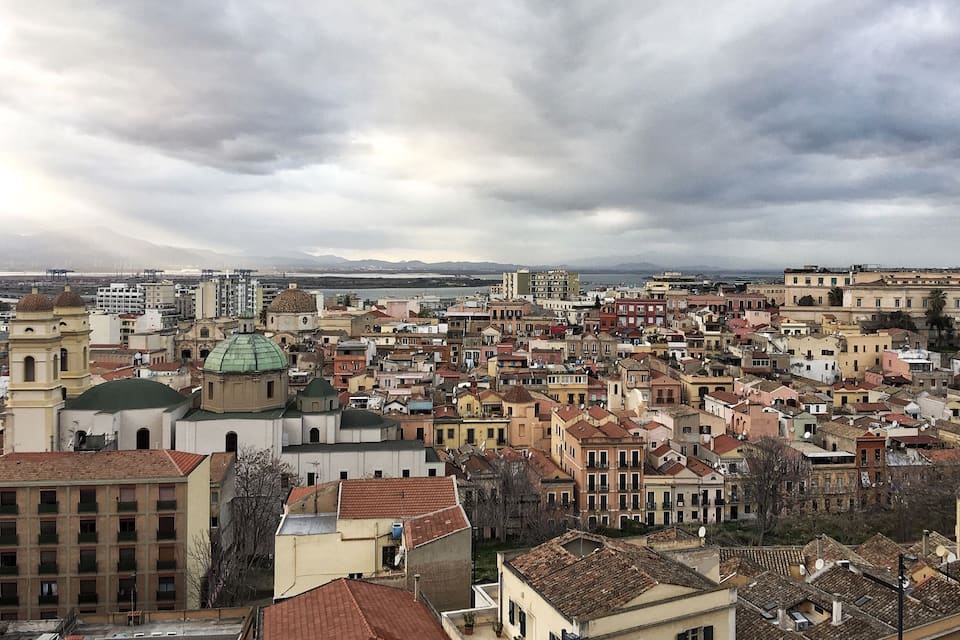 A densely packed urban area with historic buildings and a prominent church with a green dome.