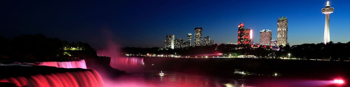 A city skyline with illuminated buildings and a prominent tower.