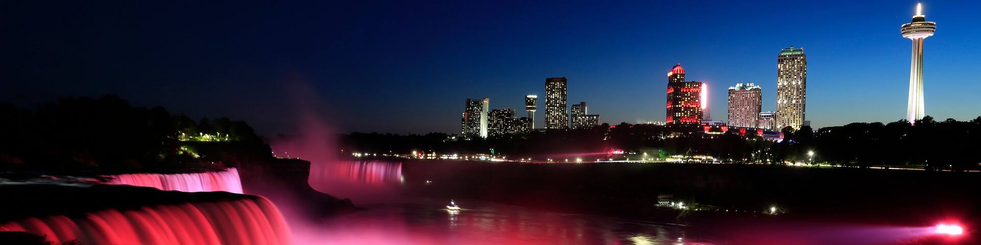 Niagara Falls at dusk including the skyline of the Canadian city of the background