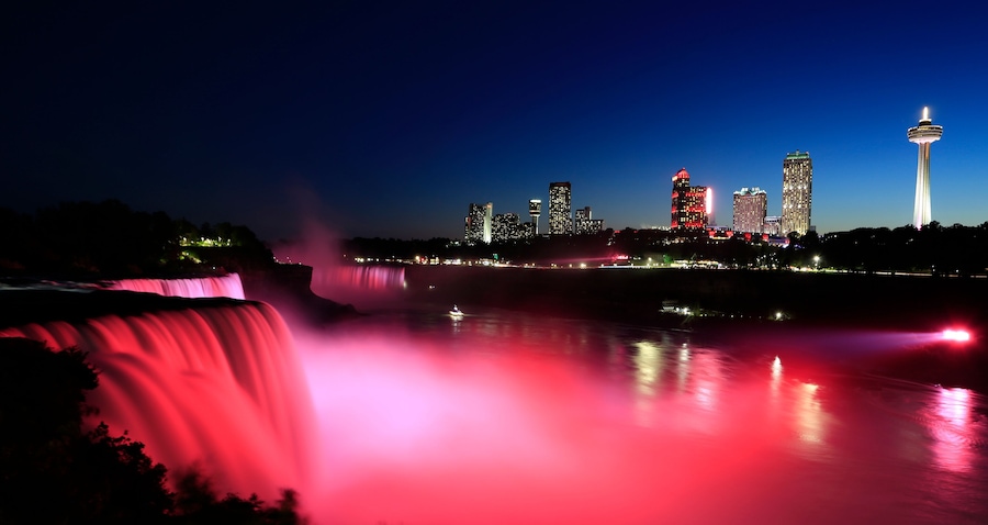 Niagara Falls at dusk including the skyline of the Canadian city of the background