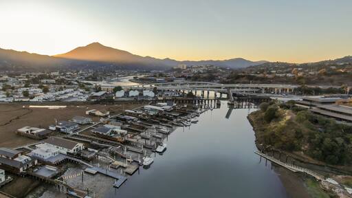 Aerial view of Corte madera Creek in Larkspur, Greenbrae, California, USA, at sunrise. Houses line the riverbank with docks and boats with Mount Tamalpais in the background.