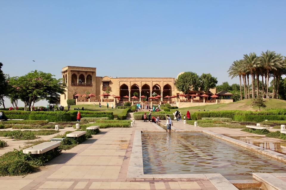 A historic building with arches and a courtyard with a water feature.
