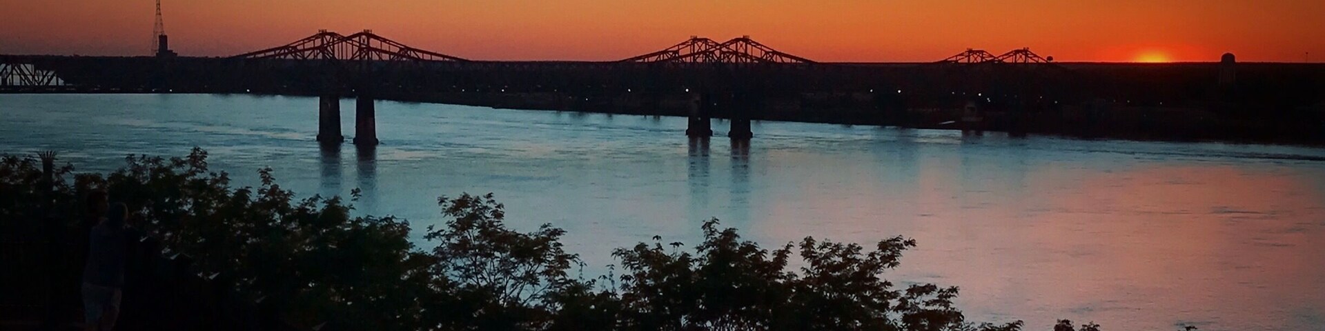 Sunset over the Mississippi River in Natchez, Mississippi. Bridge connecting Mississippi and Louisiana.