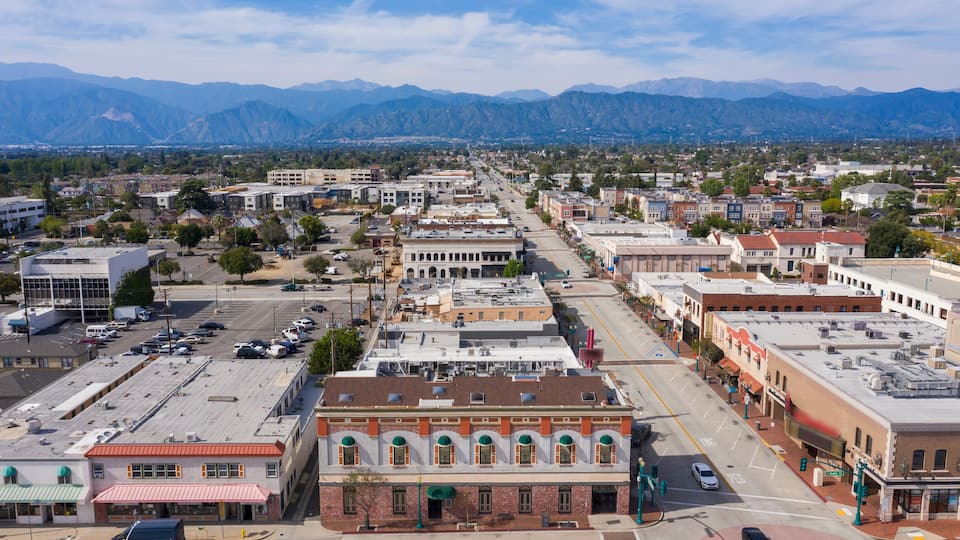 A town with historic buildings, a main street, and mountains in the background.