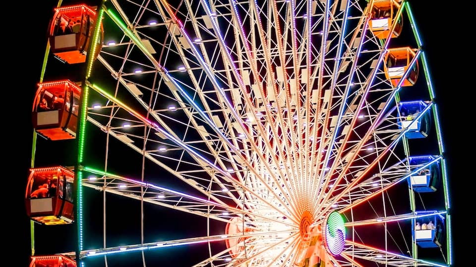 Ferris Wheel Spinning Round Illuminated in Night Sky