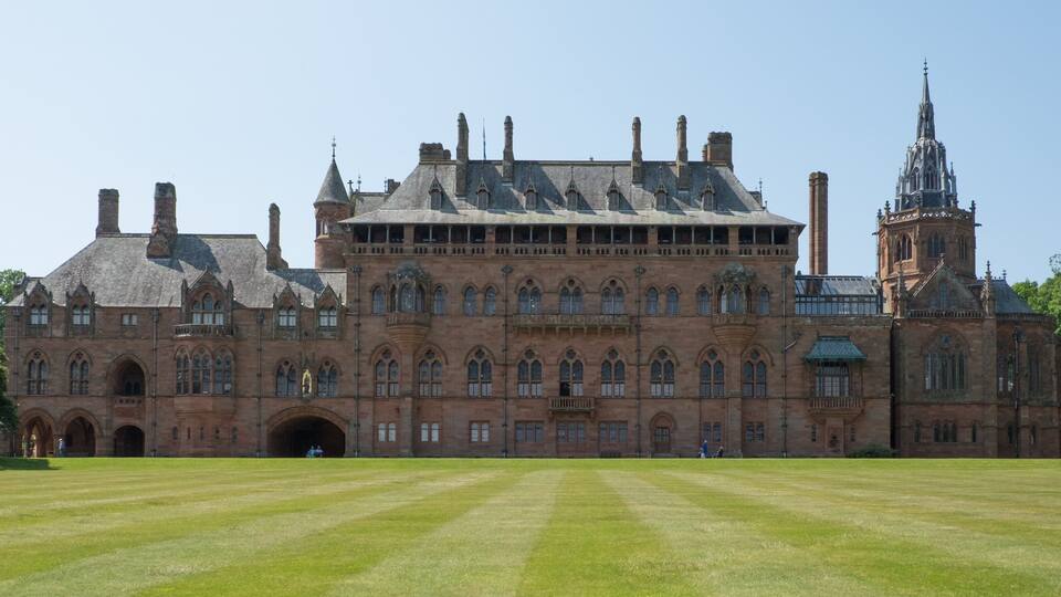 A large, historic building with multiple towers and arched windows.