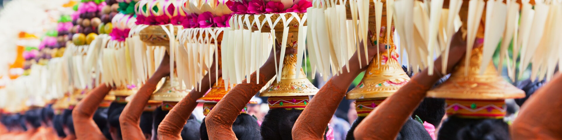 Group of beautiful Balinese women in costumes - sarong, carry offering for Hindu ceremony. Traditional dances, arts festivals, culture of Bali island and Indonesia people. Indonesian travel background