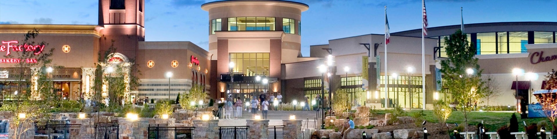 A shopping plaza with a central fountain, a clock tower, and various stores including a bakery and a casino.