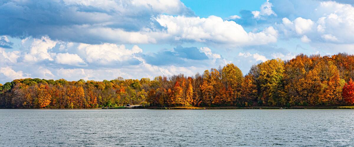 Brightly colored trees of autumn line the shore of Worster Lake at Potato Creek State Park in North Liberty, Indiana