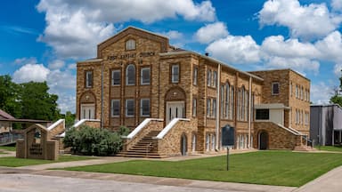 A historic First Baptist Church building with a brick facade, arched windows, and a prominent entrance.