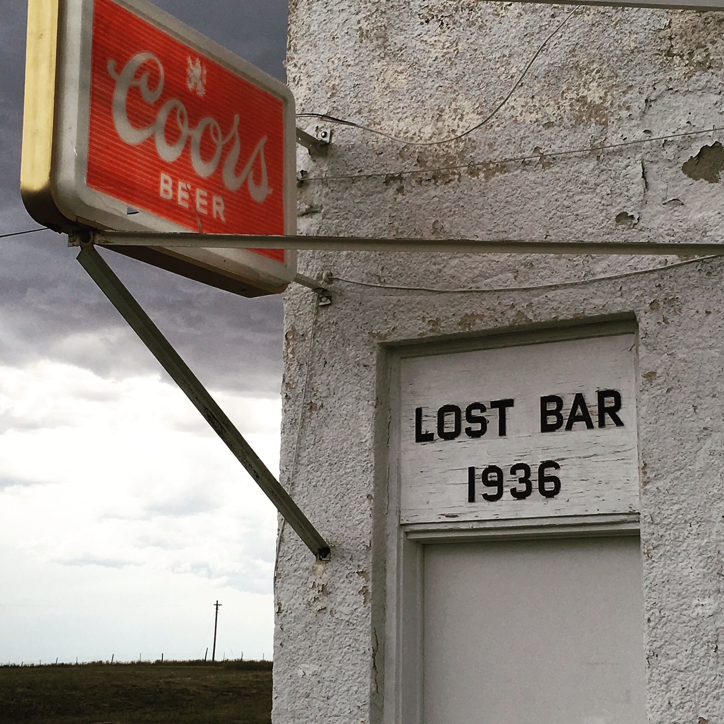 A sign for a 'Lost Bar' from 1936 and a 'Cokes Beer' sign.