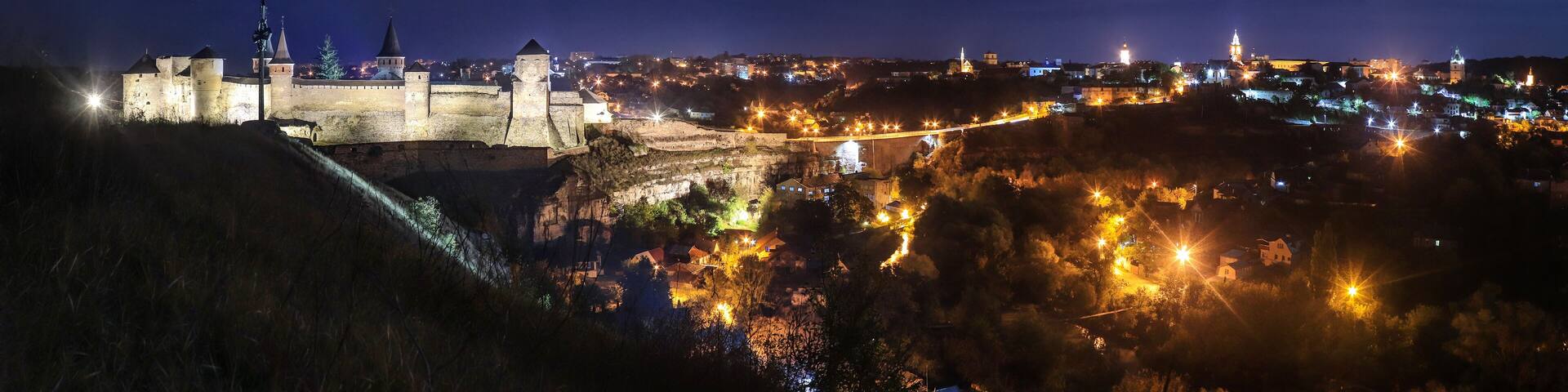 Panoramic night view of ancient fortress castle in Kamianets-Podilskyi, Khmelnytskyi Region, Ukraine. Old ?astle photo on a postcard or cover. Long exposive