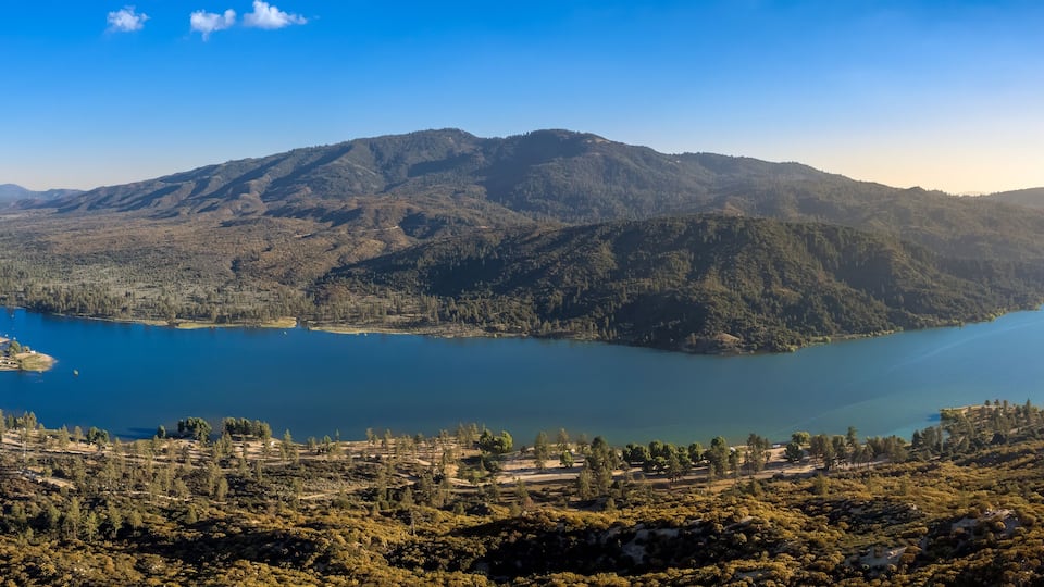 A lake surrounded by mountains and forested areas.
