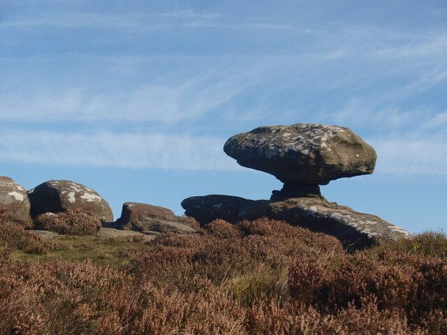 A landscape with large boulders and heather.