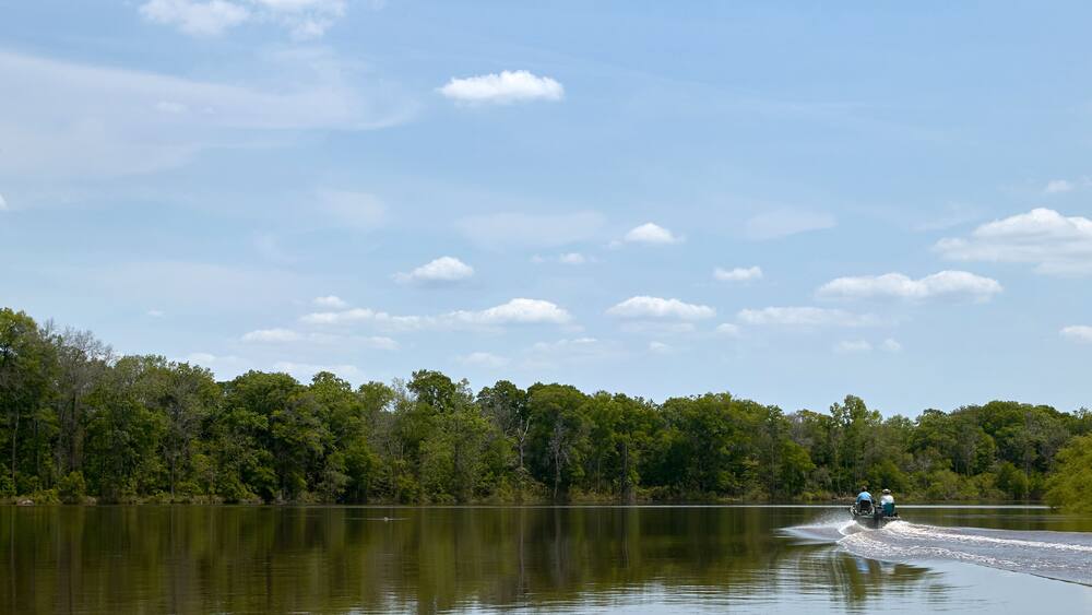 Boat on calm scenic river on a bright sunny day