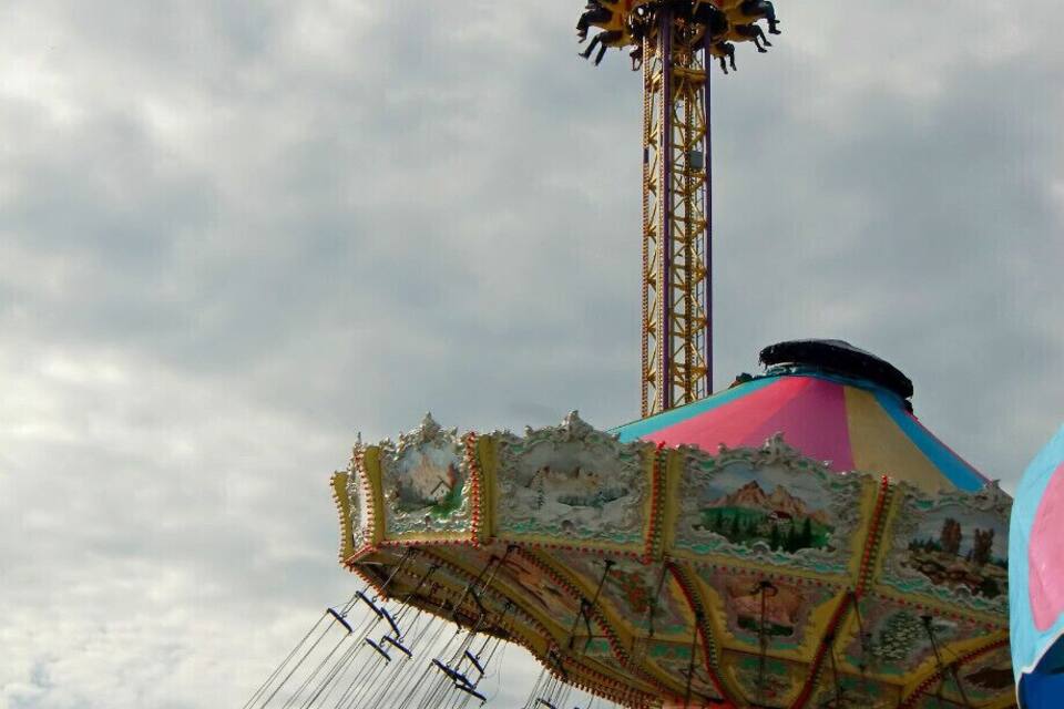 Un carrousel agrémenté de décorations colorées et doté d’une haute structure en forme de tour.