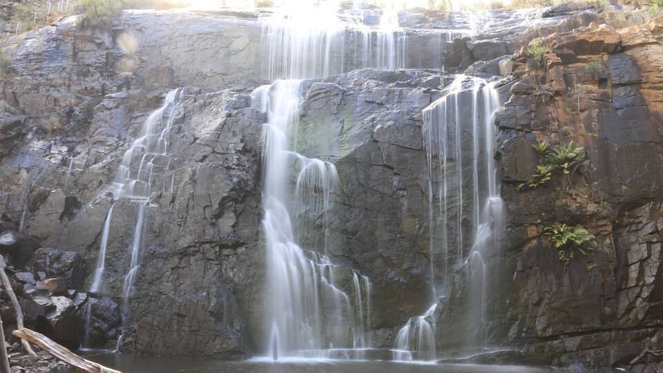A multi-tiered waterfall cascading down a rocky cliff.