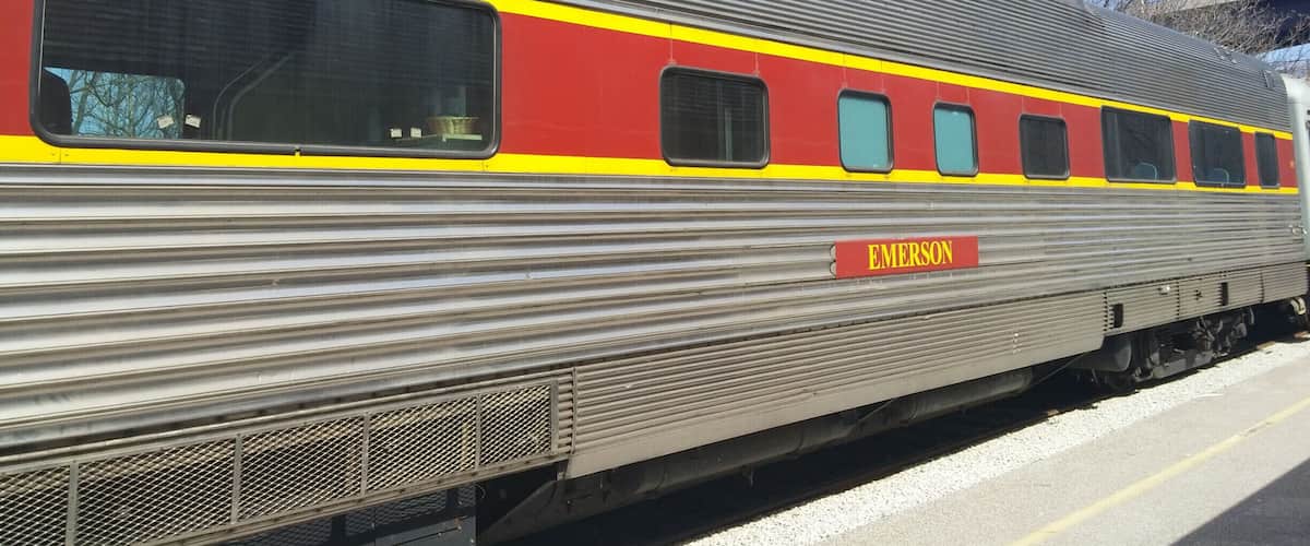A silver train with a red stripe and the word "EMERSON" on the side.