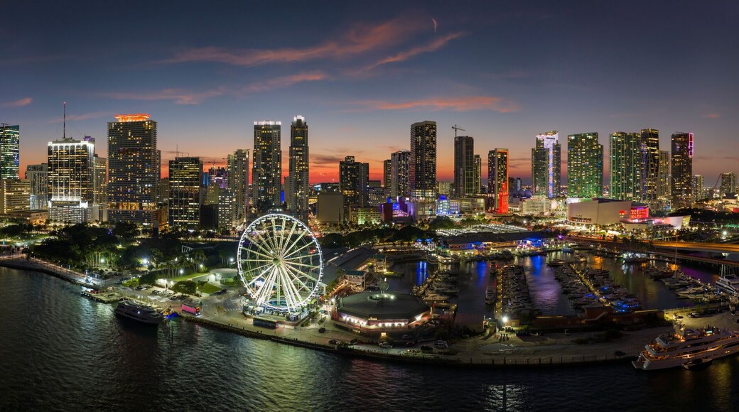 American urban landscape at night. Miami marina and Skyviews Observation Wheel at Bayside Marketplace with reflections in Biscayne Bay water and skyscrapers of Brickell, city's financial center