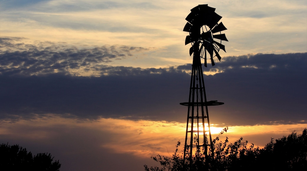 Kansas Sunset with a colorful sky and clouds with a Windmill silhouette north of Hutchinson Kansas USA.