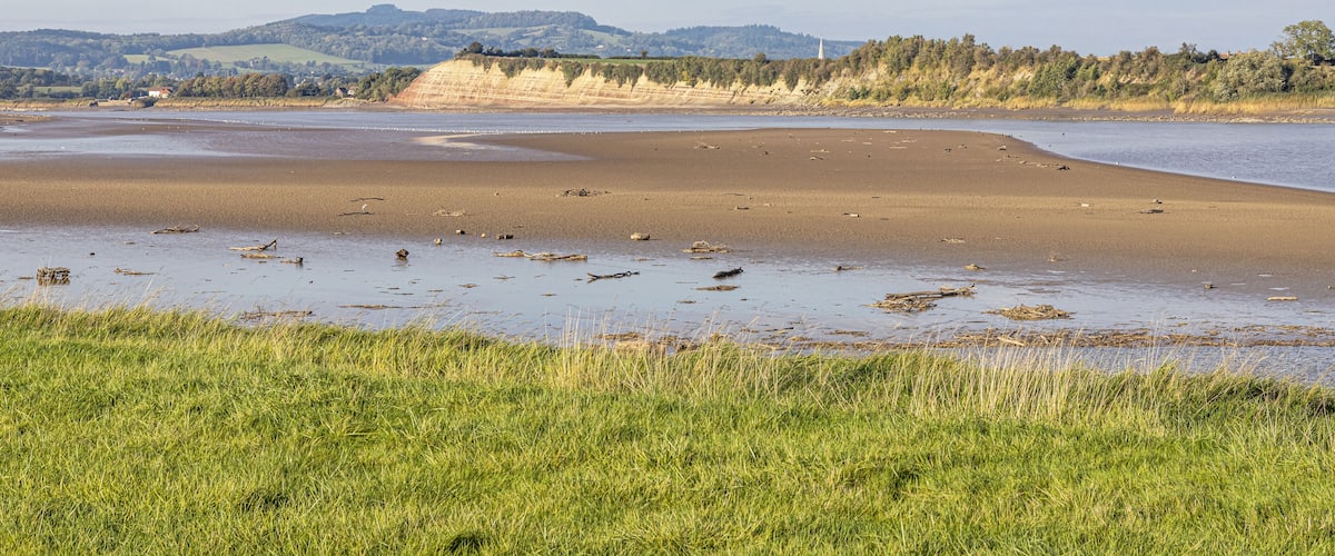 The River Severn at low tide at Arlingham, Gloucestershire, England UK - Westbury Garden Cliff is on the far bank.