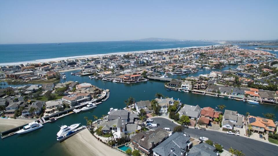 A coastal town with a marina, residential buildings, and a beach.