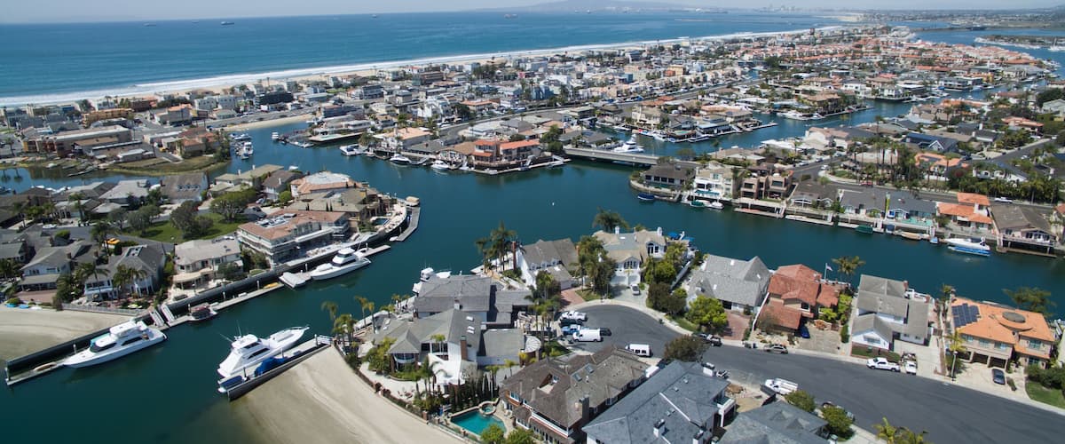 A coastal town with a marina, residential buildings, and a beach.
