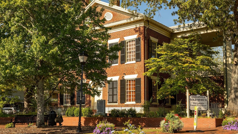 A historic building with a brick facade, large windows, and a sign for the Dahlonega Gold Museum.