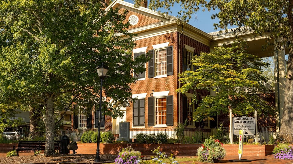 A historic building with a brick facade, large windows, and a sign for the Dahlonega Gold Museum.