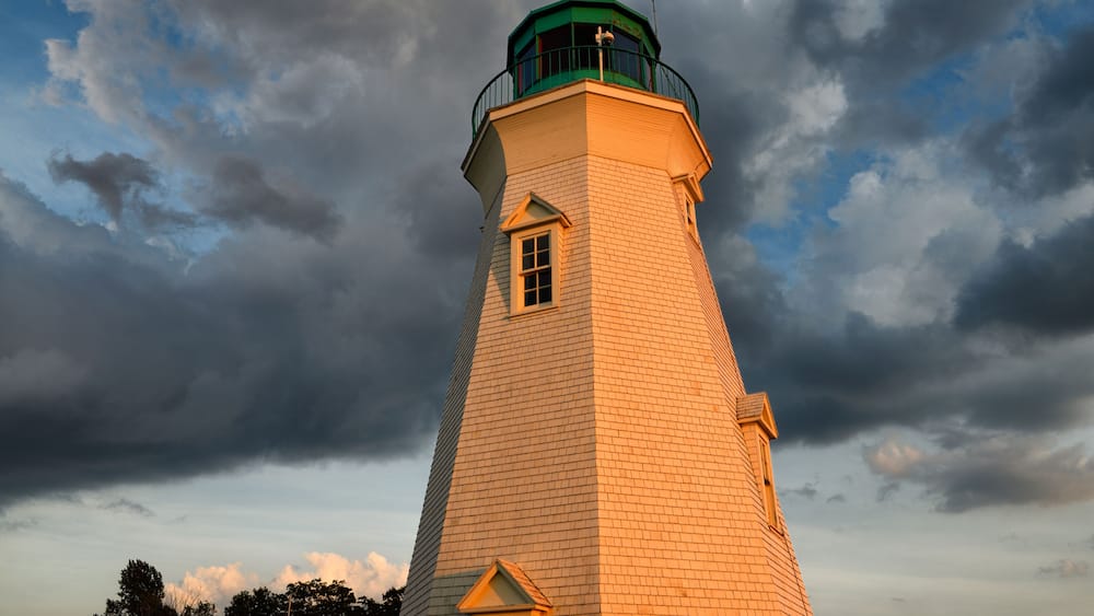 Glowing red light on white Octagonal Port Dalhousie Inner Range Lighthouse in at sunset with clouds St. Catherines Ontario Canada