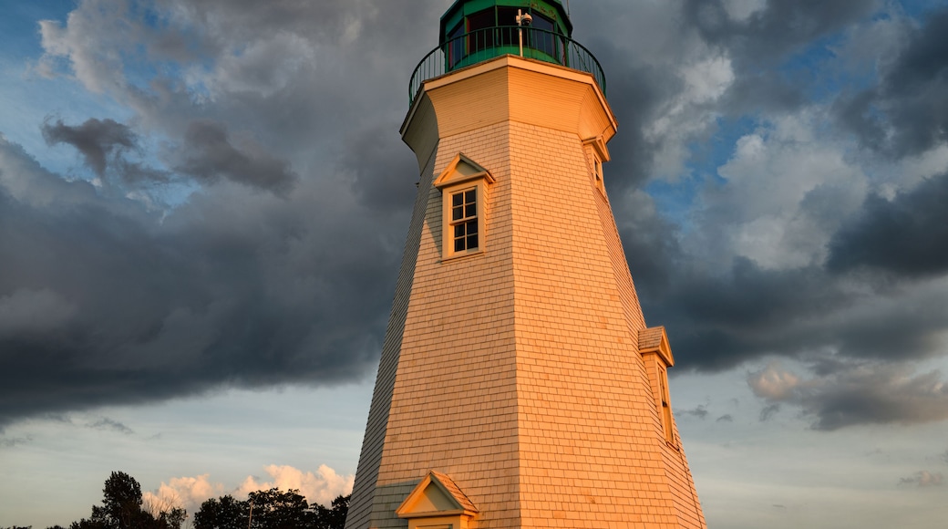Glowing red light on white Octagonal Port Dalhousie Inner Range Lighthouse in at sunset with clouds St. Catherines Ontario Canada