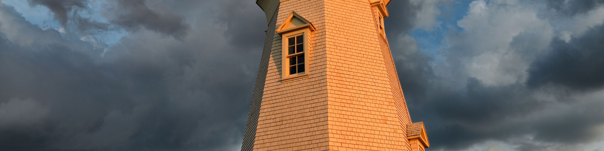 Glowing red light on white Octagonal Port Dalhousie Inner Range Lighthouse in at sunset with clouds St. Catherines Ontario Canada