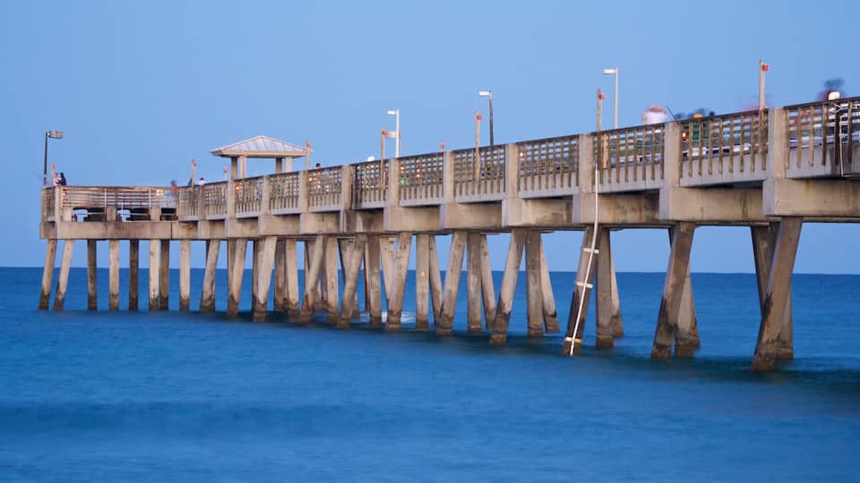A pier extending into the water with a covered seating area and a small pavilion.