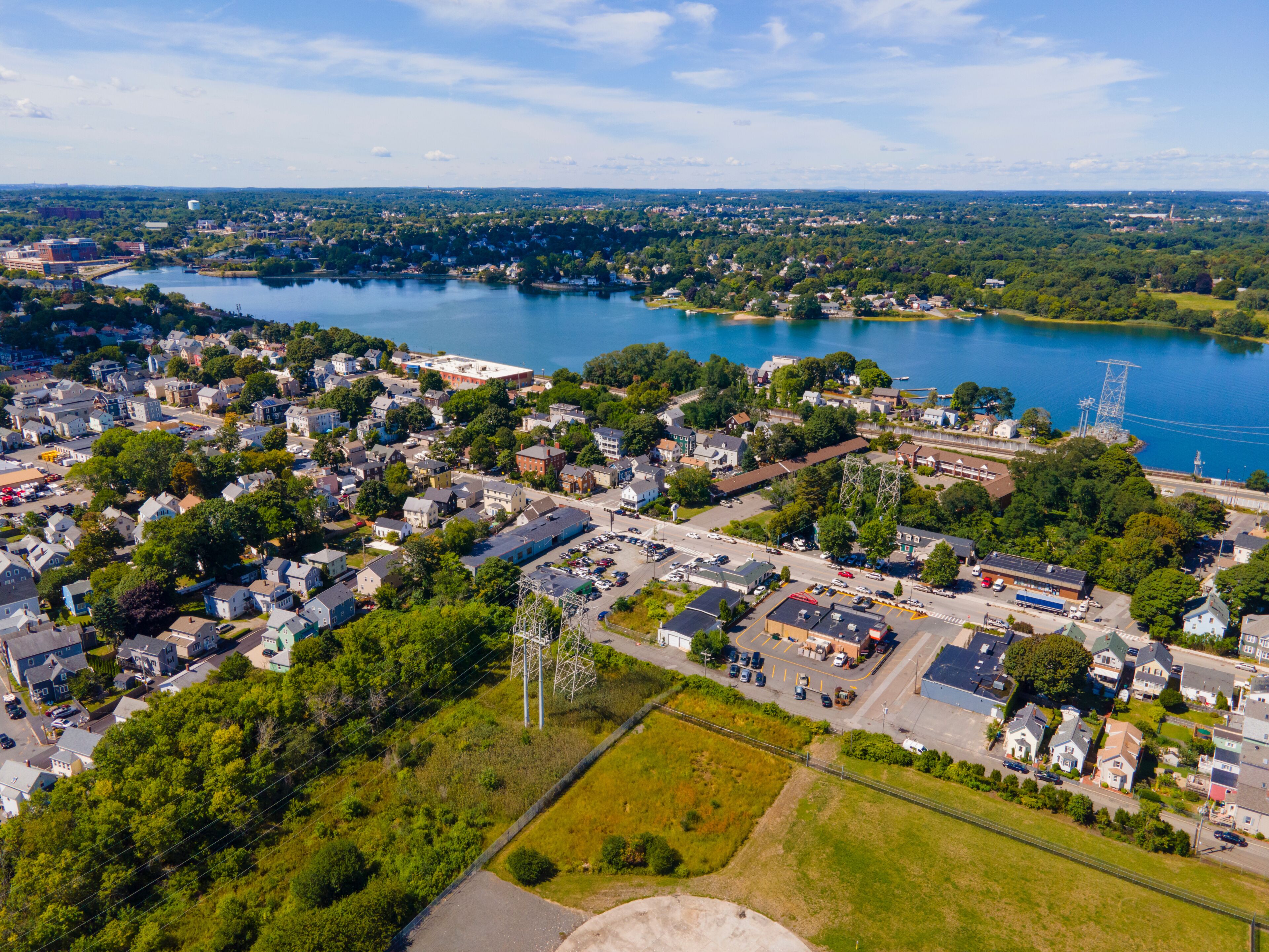 A town with a river, green spaces, and a mix of residential and commercial buildings.