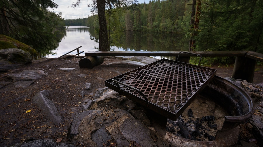 Campfire grill next to tranquil lake in Finland