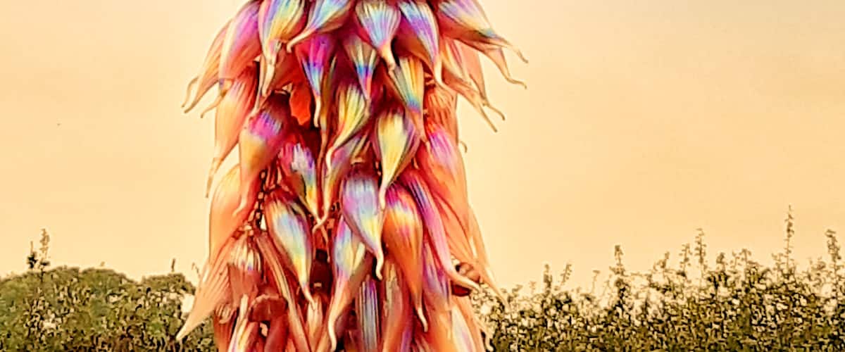 A tall, colorful flower sculpture against a clear sky.