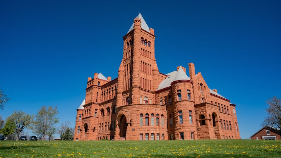 A large brick building with a prominent tower and arched windows.