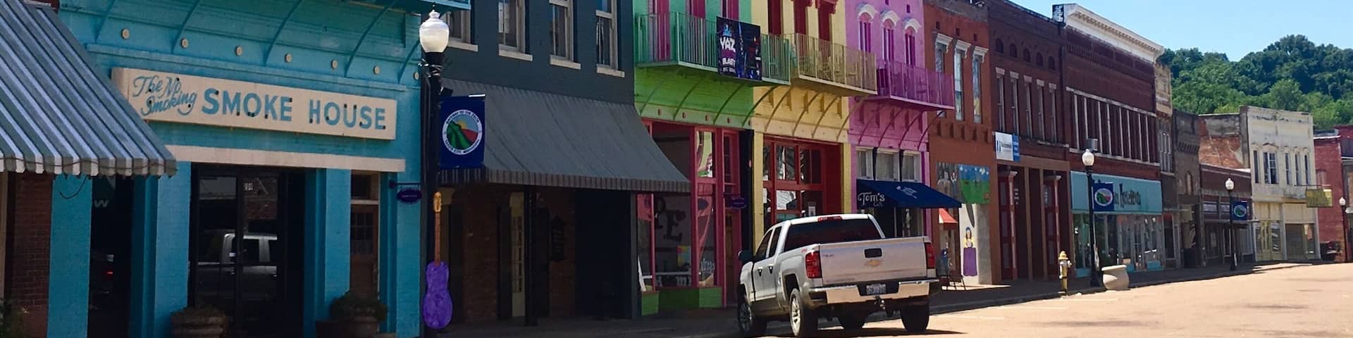 Driving through Mississippi, I had a chance to stop at Yazoo City! I instantly regretted traveling on a holiday because the downtown area looked like so much fun but everything was closed. The building are painted in bright colors and there are plywood guitars with different designs painted on them all along both sides of the road.
There’s also a children’s area where a mural has been painted.